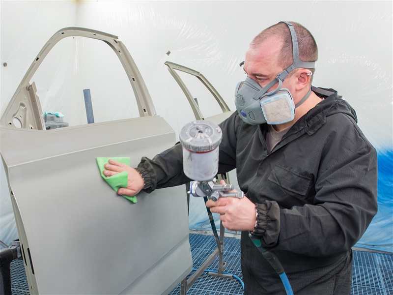 Eine Fahrzeugtüre vor dem Lackieren entstauben