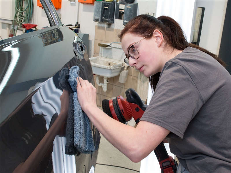 Ein lackiertes Fahrzeugteil polieren