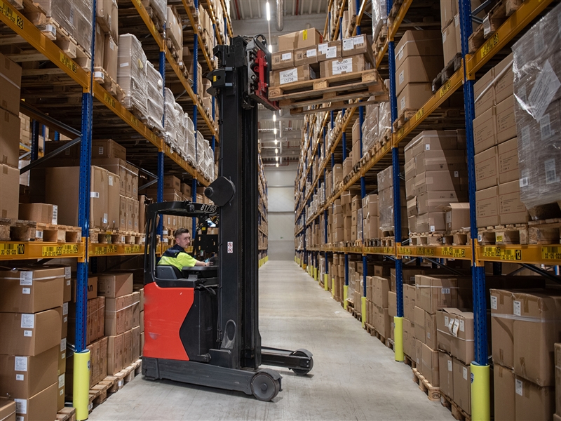 Im Hochregallager mit dem Regalstapler eine Palette absetzen