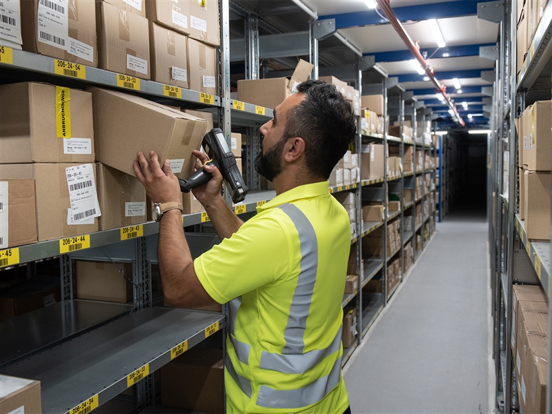 Ein Paket softwaregestützt im Kommissionslager zwischenlagern