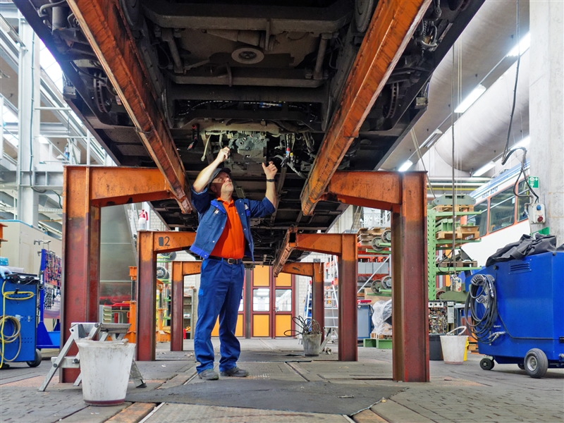 Am Montagestand ein Ersatzteil an einer Straßenbahn verschrauben