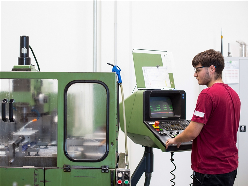 In der Werkstatt ein Werkstück an der Fräsmaschine bearbeiten