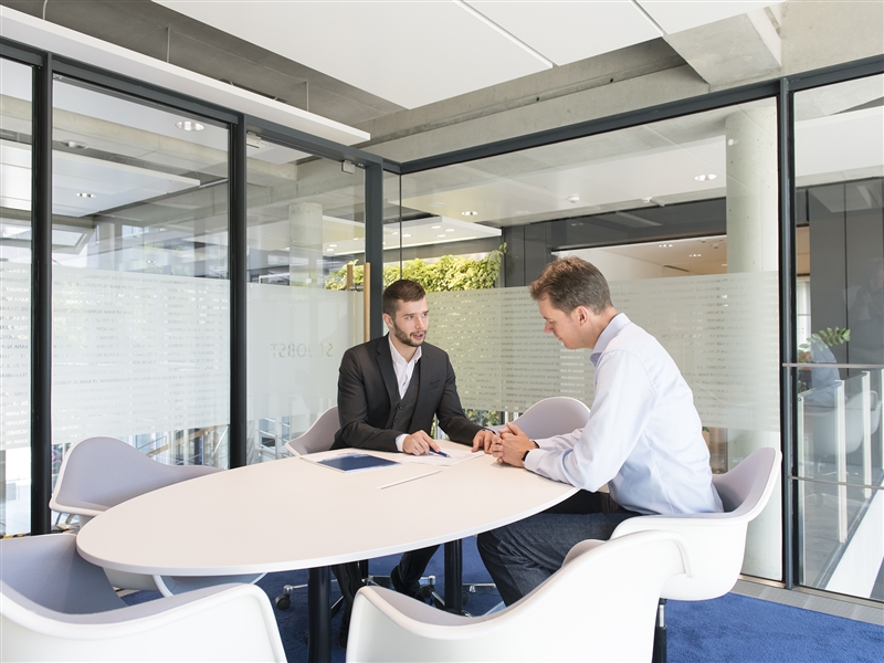 Im Besprechungsraum einem Kunden Darlehensvarianten erläutern